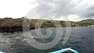 Boat outriggers moving through ocean waves