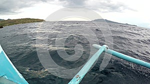 Boat outriggers moving through ocean waves