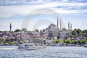 Boat Passing Historic Mosque on Hillside of Istanbul