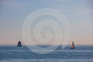 A boat passing New London Ledge Lighthouse in Groton, Connecticut on the Thames River