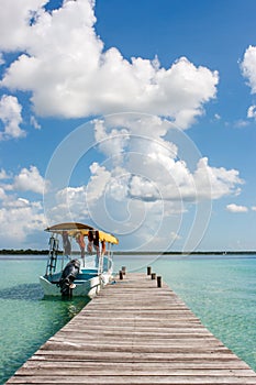 Boat at the pier with clouds and blue water at the Laguna Bacalar, Chetumal, Quintana Roo, Mexico.