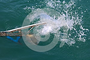 The boat propellers spinning in the sea water from the diesel engine. long tail boat