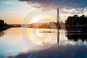 Boat regatta/rowing team silhouette on the tranquil lake at sunset