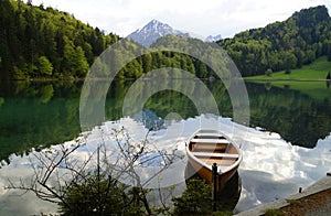 boat resting on transparent emerald-green water of lake Alatsee near the Fussen town in Bavaria, Germany photo