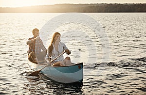 Boat ride and sunshine. a young couple rowing a boat out on the lake.