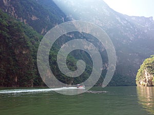 A boat rides down the Sumidero Canyon as sunlight bursts through in the morning in Chiapas State