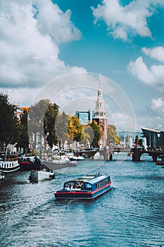 Boat on river Amstel in Amsterdam Netherlands landmark old european city landscape. Picturesque cloudscape