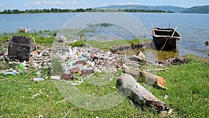 Boat by the river bank full of garbage