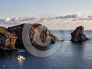 Boat and rocks in mediterranean sea. Pantelleria Island, Italy