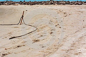 boat rope and footprints on sand at beach