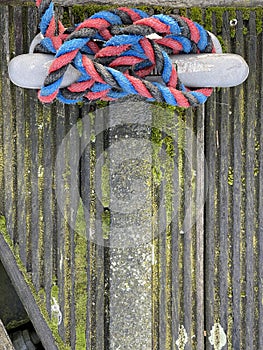 Boat rope tied on pier bollard on wooden pier