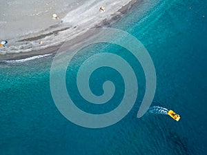 Boat sailing from above and coastline stretch of coast, beach and vacations, relaxation. Aerial view