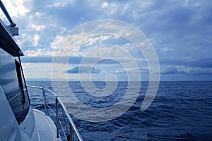 Boat sailing in cloudy stormy day blue ocean