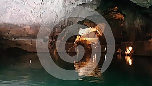 The boat is sailing during the excursion through the cave, Altinbasak in Turkey. Cave lake with beautiful lighting.