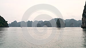 Boat sailing through the limestone islands in Ha Long Bay, Cat Ba National Park, Vietnam