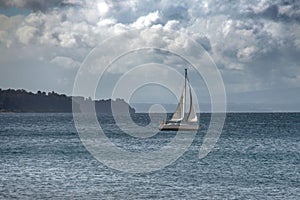 Boat sailing on the Llanquihue lake under a cloudy sky in Frutillar, Chile