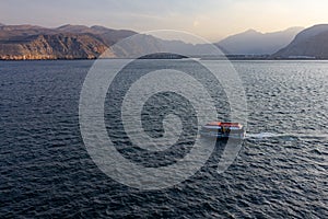 Boat sailing in Oman fjords, sea mountain landscape, Khasab