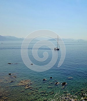 the boat is sailing in the sea near rocks and a large island