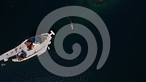 Boat sails between the islands of Gospa od Skrpjela and St. George across the bay. Drone