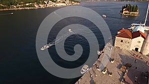 Boat sails on the sea past the island of Gospa od Skrpjela. Top view 360