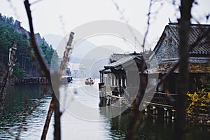 a boat sails through the water next to small houses on a dock