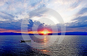 Boat in scarlet sunset on Ohrid Lake in September