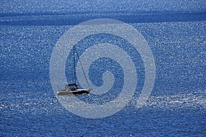 Boat at sea. A lone sailboat in the blue sea