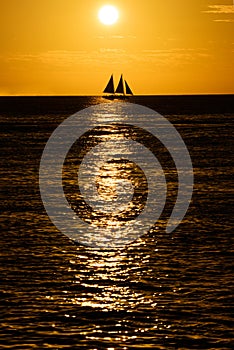 Boat on the sea at sunset. Sailboats with blue sails at sunset.