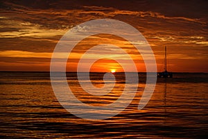 Boat on the sea at sunset. Sailboats with sails. Ocean yacht sailing along water.