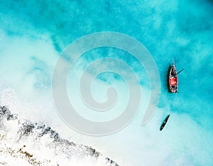 Boat and ship in beautiful turquoise ocean, top view