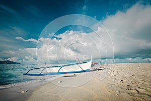Boat at the shore of Zambales, Philippines under the blue sky and the cotton clouds