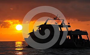 Boat silhouetted at sunset