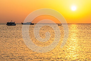 Boat silhouetts on the shores of the red sea at sunset in Makadi Bay Egypt golden colors photo
