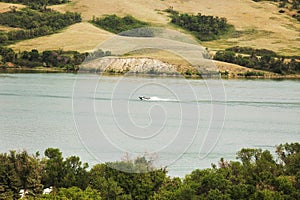 A boat skimming across a lake