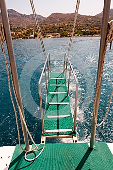 Boat stairs to the blue sea
