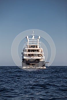 The boat stern of huge yacht in sea at sunny day, glossy board of the motor boat, the chrome plated handrail, megayacht