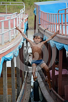 Boat Swinging Boy at Tonle Sap Lake Fishing Village Cambodia