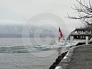 Boat with Swiss Flag on Lake Lucerne in Winter.