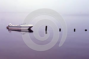 Boat tied to pylons from the remnants of a dock