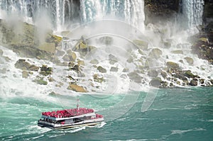 Boat with tourists sailing towards Niagara falls photo