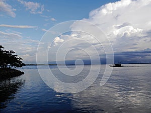 Boat on tranquil Kinabatangan River with reflections , Sabah, Malasia photo