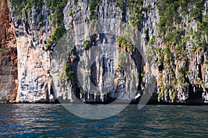 Boat trip around impressive steep cliffs of tropical island Ko Phi Phi, Thailand