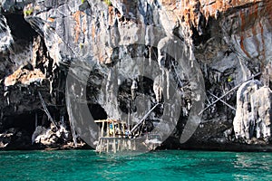 Boat trip around impressive steep rough cliffs of tropical island Ko Phi Phi, Thailand
