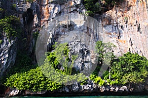 Boat trip around impressive steep rough cliffs of tropical island Ko Phi Phi, Thailand