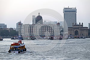 Taj Mahal hotel, Gateway of India and tourist boats in water of Arabian Sea in Mumbai