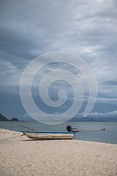 Boat in the tropical sea under gloomy dramatic sky.