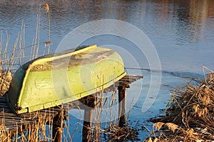 Boat turned upside down lying on small fishing pier at a lake sh