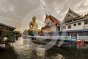 A boat was passing Big Buddha statue (Phra Buddha Dhammakaya Thepmongkhon ) in Wat Pak Nam Phasi Charoen temple