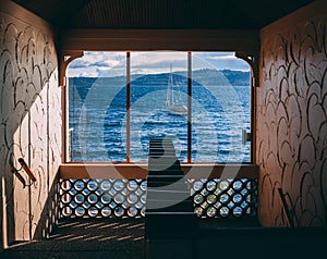 Boat on water as seen through window in stair well