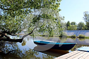 Boat on the water tied to a bridge in a calm sunny morning